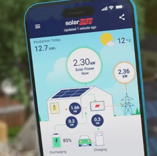 Un technicien BESSEnr sur un toit en Savoie, utilisant une brosse de nettoyage professionnelle télescopique pour enlever la poussière et le pollen sur un panneau solaire